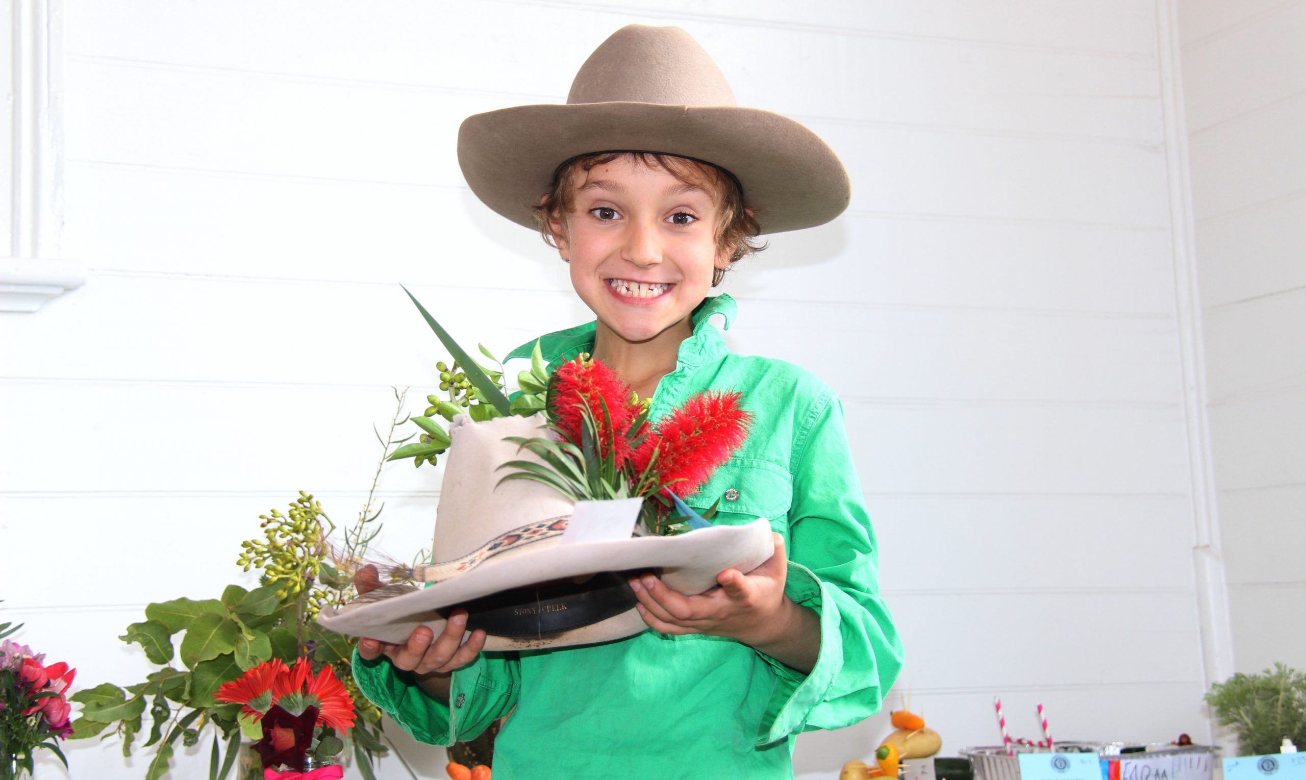 Frank Pike wearing his signature hat and holding his impressive floral hat creation, at the Burren Junction Flower Show on Sunday.