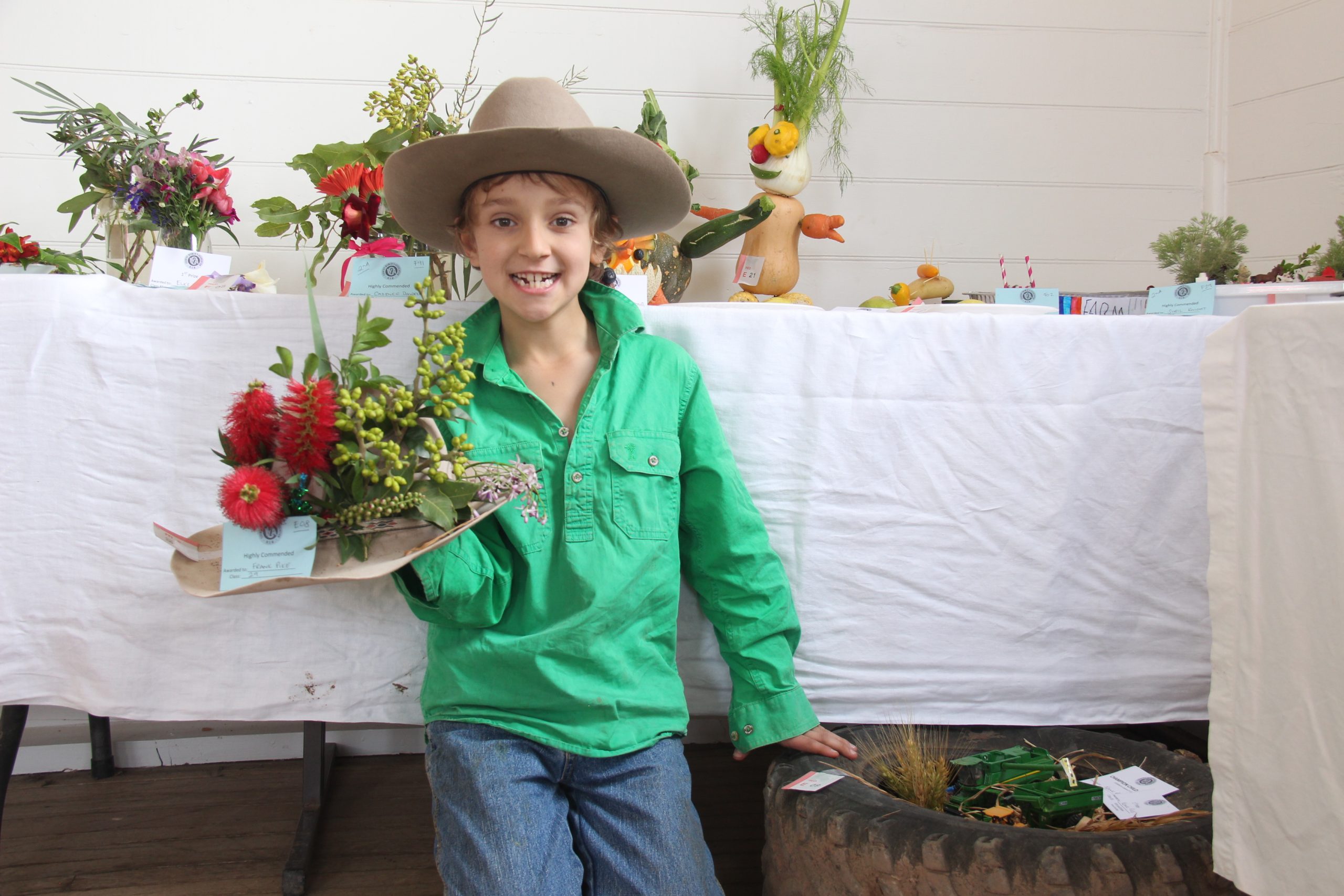 Frank Pike wearing his signature hat and holding his impressive floral hat creation, at the Burren Junction Flower Show on Sunday.