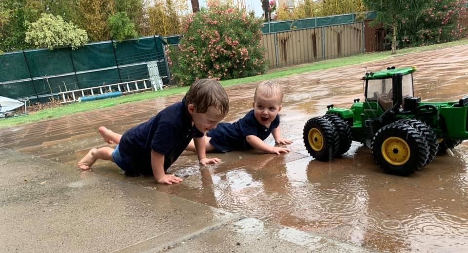 Wee Waa brothers three-year-old Sam and one-year-old Ben Deacon playing in the rain on Sunday afternoon.