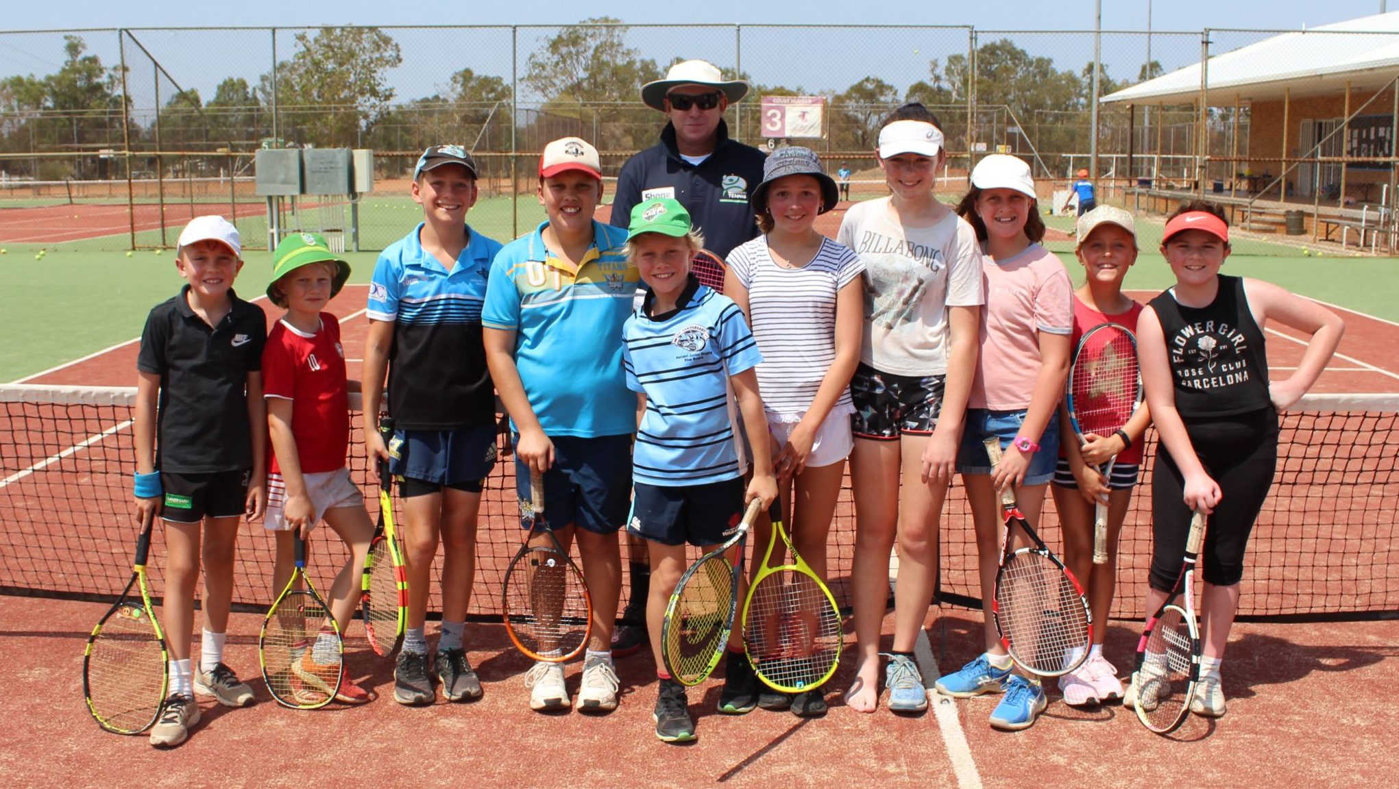 Young tennis aces brace the summer heat at school holiday clinic