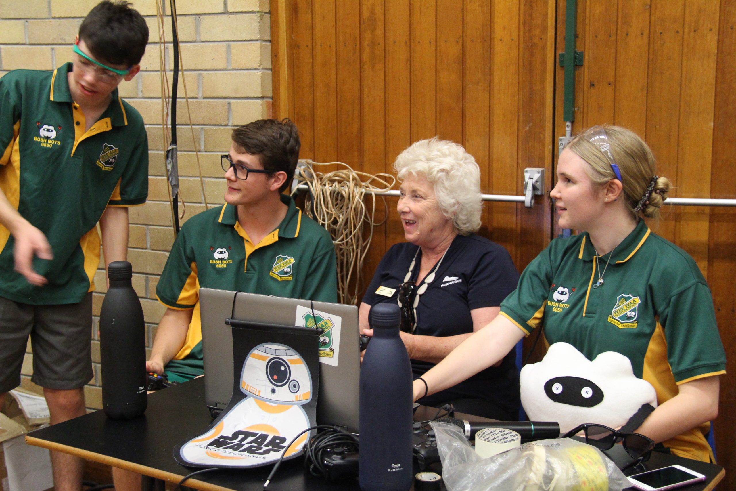 Bush Bots Isaac Weaver, Michael Horner and Alice Haire showing Mayor Cathy Redding how to control the robot BB5.