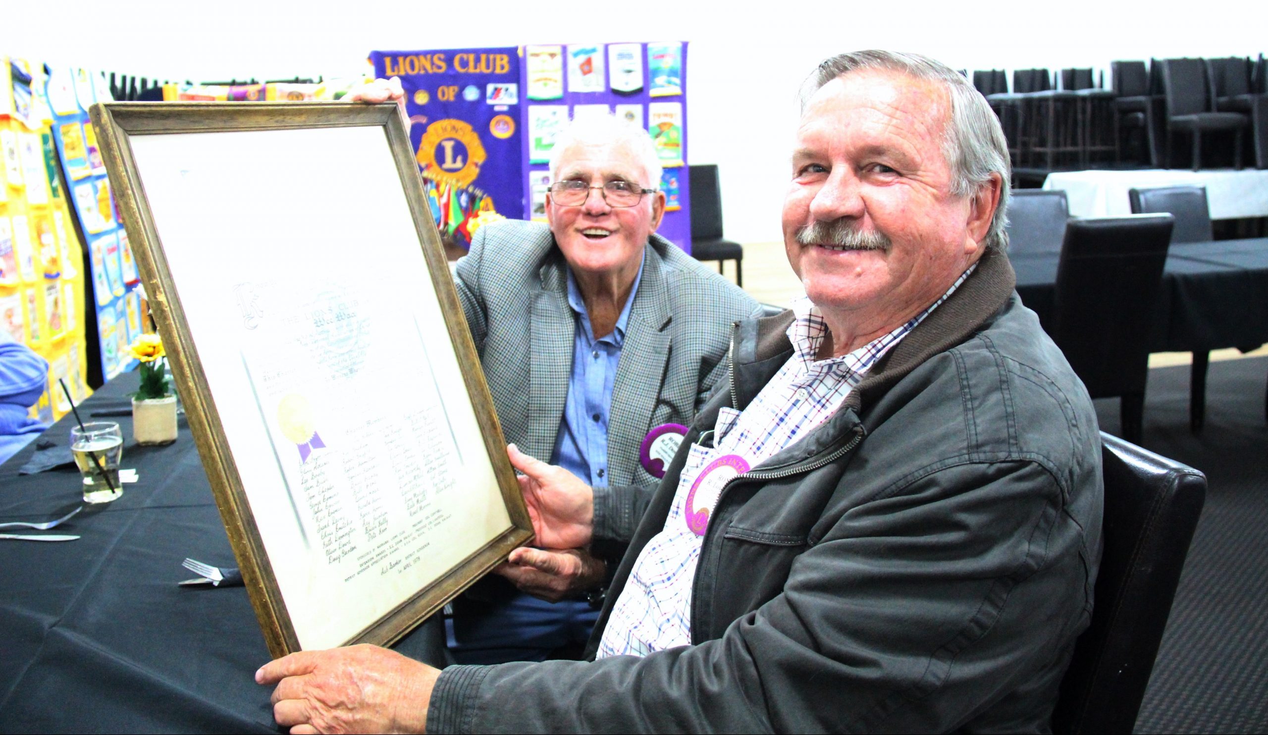 Rob Downey and Ron Lowder holding the Wee Waa Lions Club’s charter, chartered on April 1, 1978.