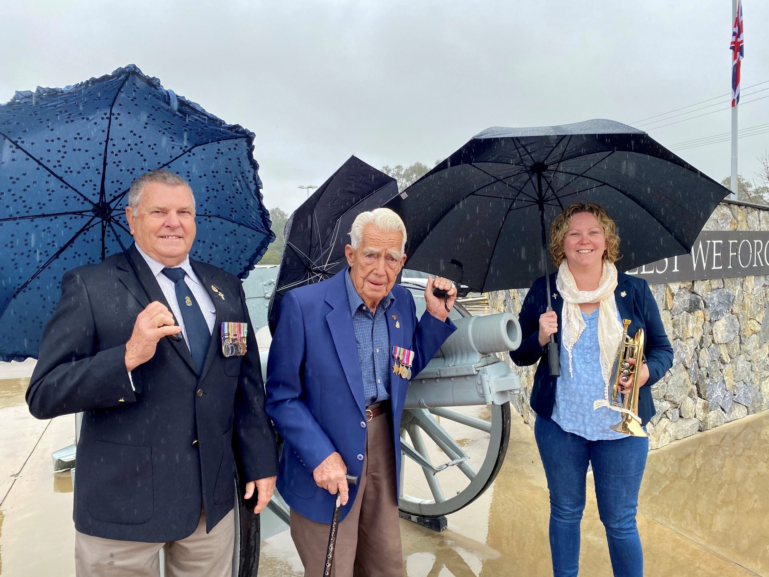Rain, hail or shine: Vietnam Veteran Dennis Lowder, World War II veteran John Collett and bugler Sarah Smith at the commemoration service held at the Narrabri RSL Club on Saturday to mark the 75th anniversary of VP (Victory in the Pacific) Day, the end of World War II.
