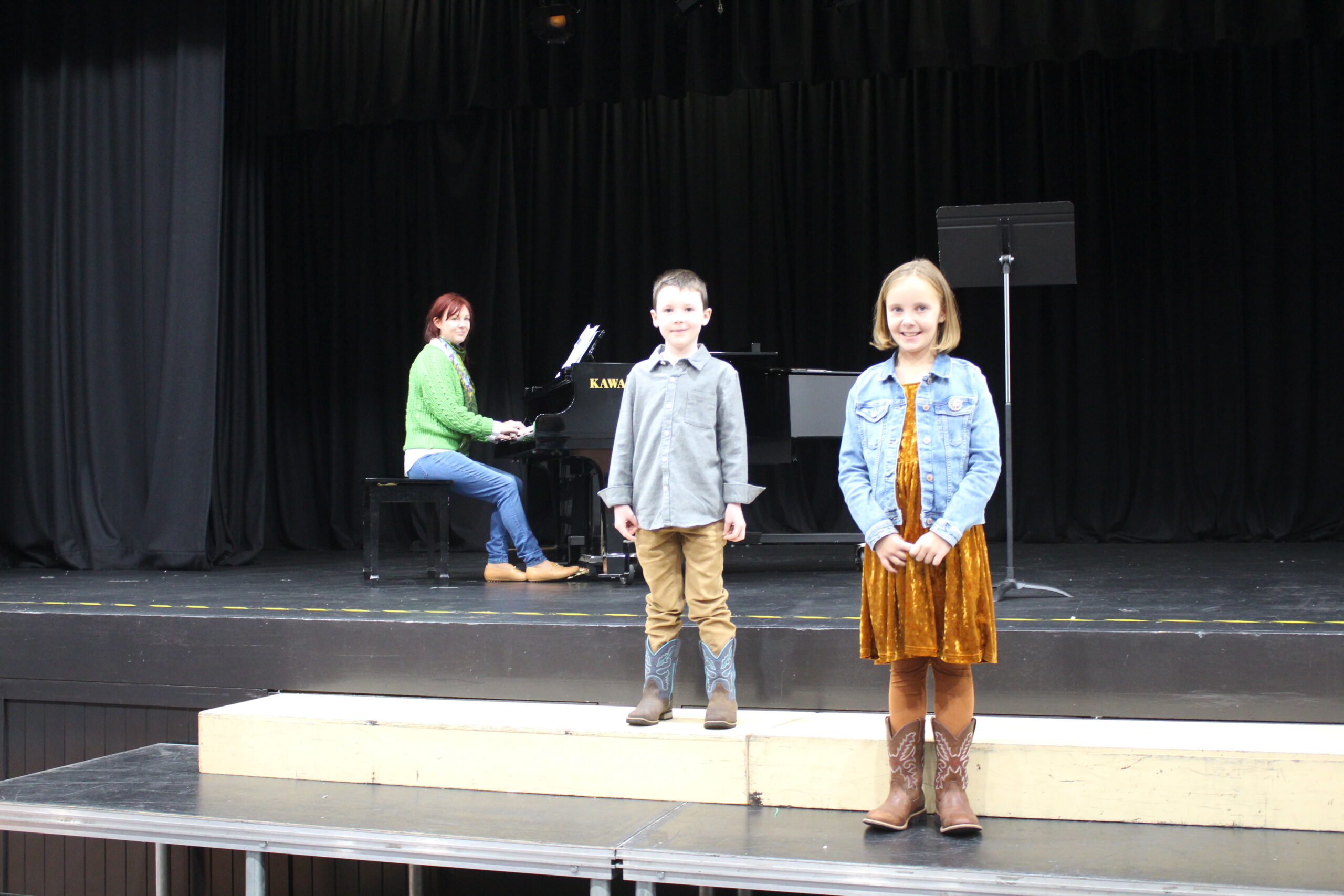 Winners of the primary duet vocal section Hugo Lillyman and Ruby-Tuesday Davis-Drenkhahn with their mother Jacqualyn Drenkhahn (in back) on piano.