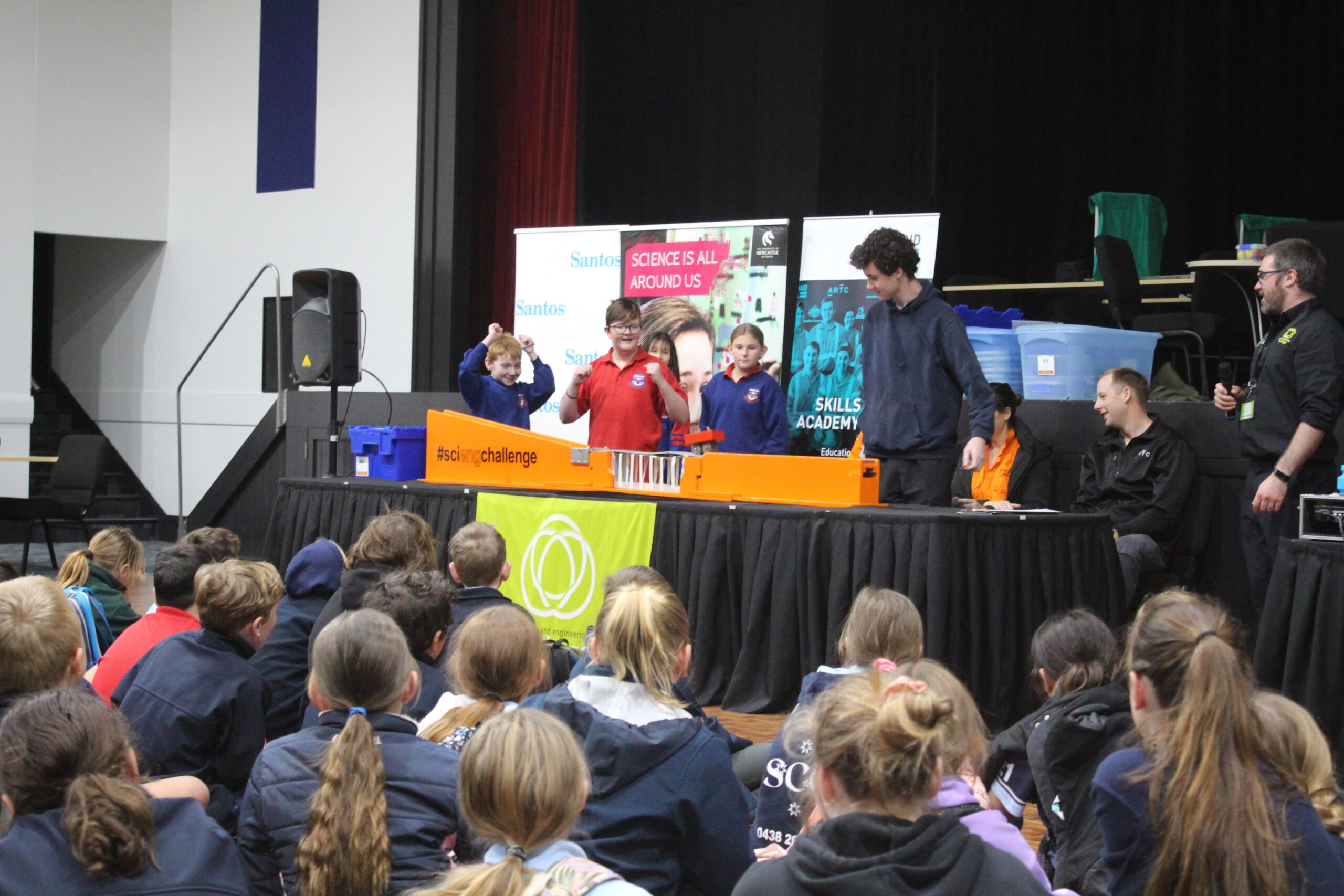 Narrabri West Public School students Jonothan Anderson, Lucas Griffiths, Riley Firth, (obscured) and Hayley Gordon in front of the audience, celebrating their bridge withstanding the weighted vehicle test.