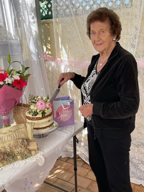 June Fogarty cutting her birthday cake made by granddaughter Levii Klaus.