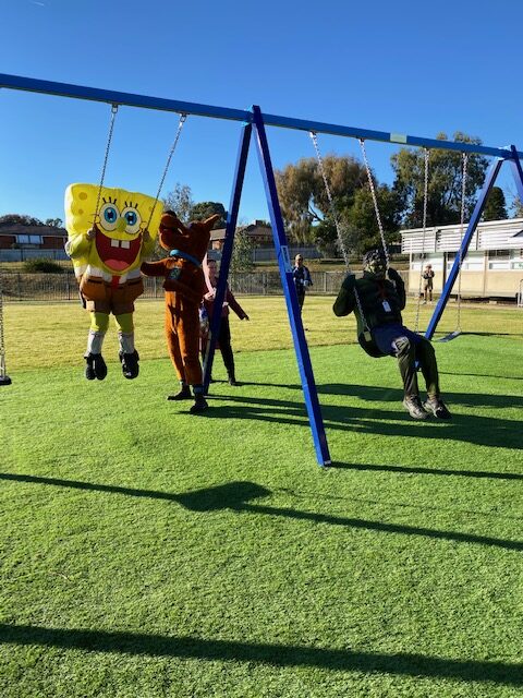 SpongeBob, Scooby-Doo and The Hulk playing on the swingset at G.S. Kidd.