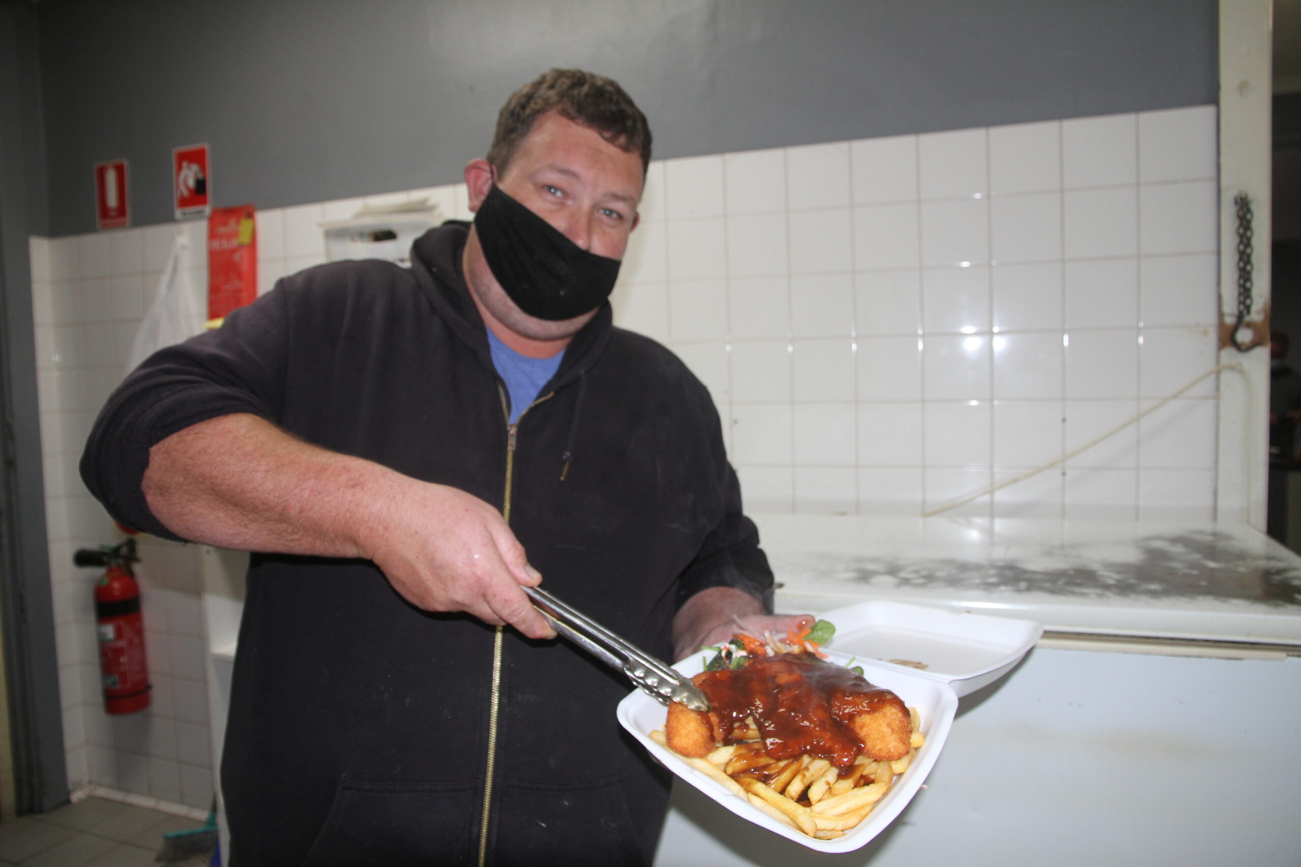 Todd Manton serves up a chicken schnitzel as part of the Namoi Hotel’s take-away service during lockdown.