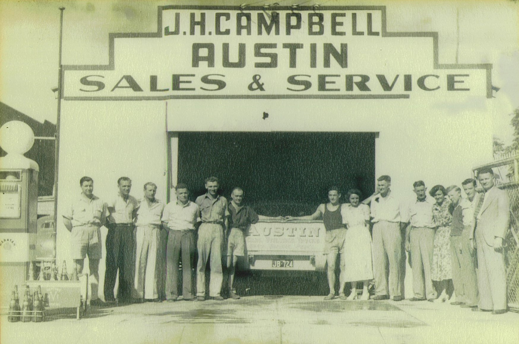 J A Campbell, Austin Agency: Photo taken about 1950 before Boyce started with the business in 1952 as an apprentice panel beater/spray painter. Bill Peno (sales manager), Jim Rook (motor mechanic), Stan Shepherdson (transport driver), Edward Armstrong (spare parts manager), Arthur Coleman (workshop foreman), Innes Adams (spray painter), Arch Hay (apprentice mechanic), Judith Foster (office assistant), Percy Armstrong (labourer), Keith Petrie (salesman - earthmoving), Fay Delaney (secretary to JH Campbell), Ron Campbell (apprentice mechanic), Fred Peno (motor mechanic) and JH Campbell (proprietor). This is now the site of Cafe One23 and backed on to Tibbereena Street.