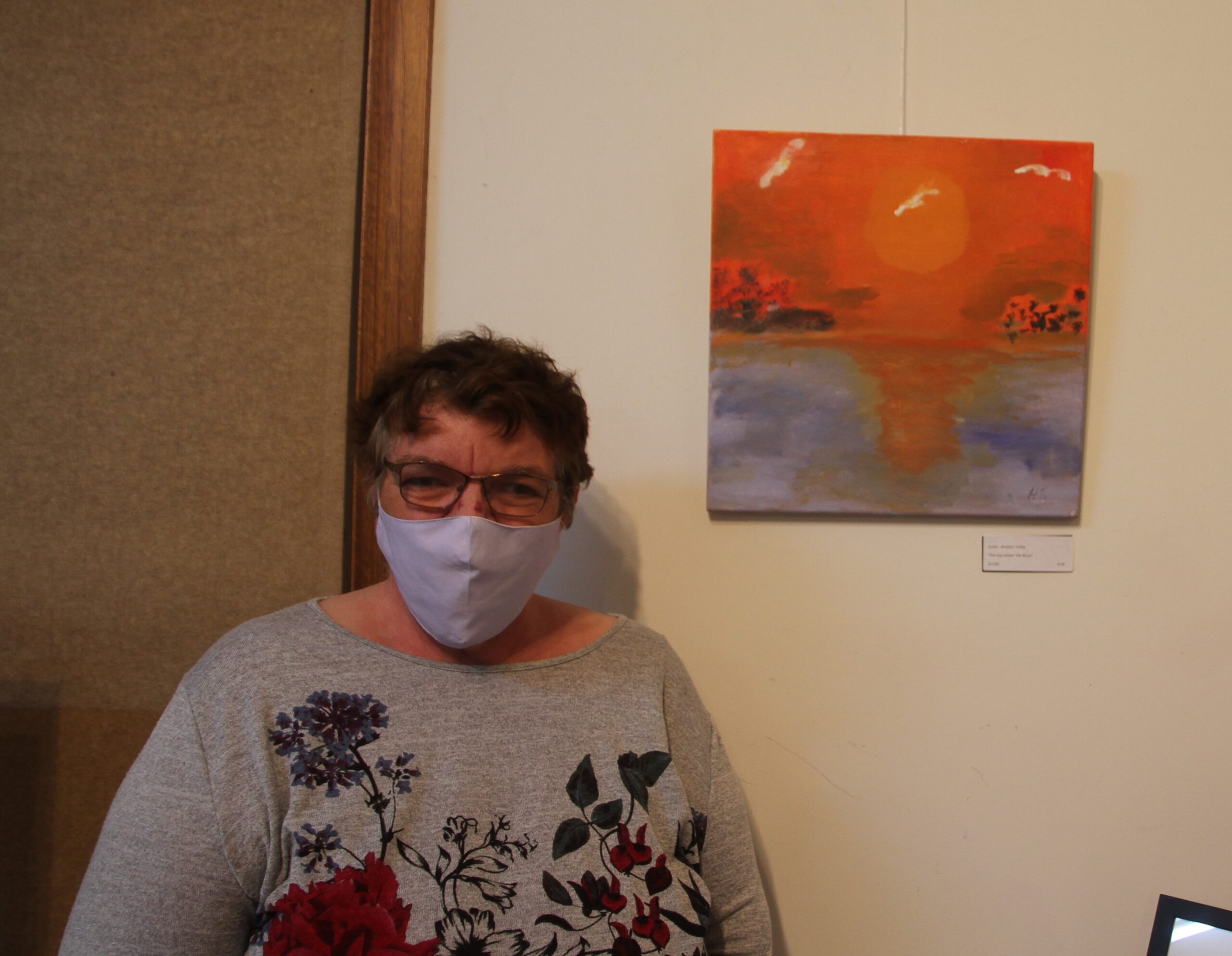 Heather Tailby with her exhibit ‘The Sun Kisses the River’ in acrylics.