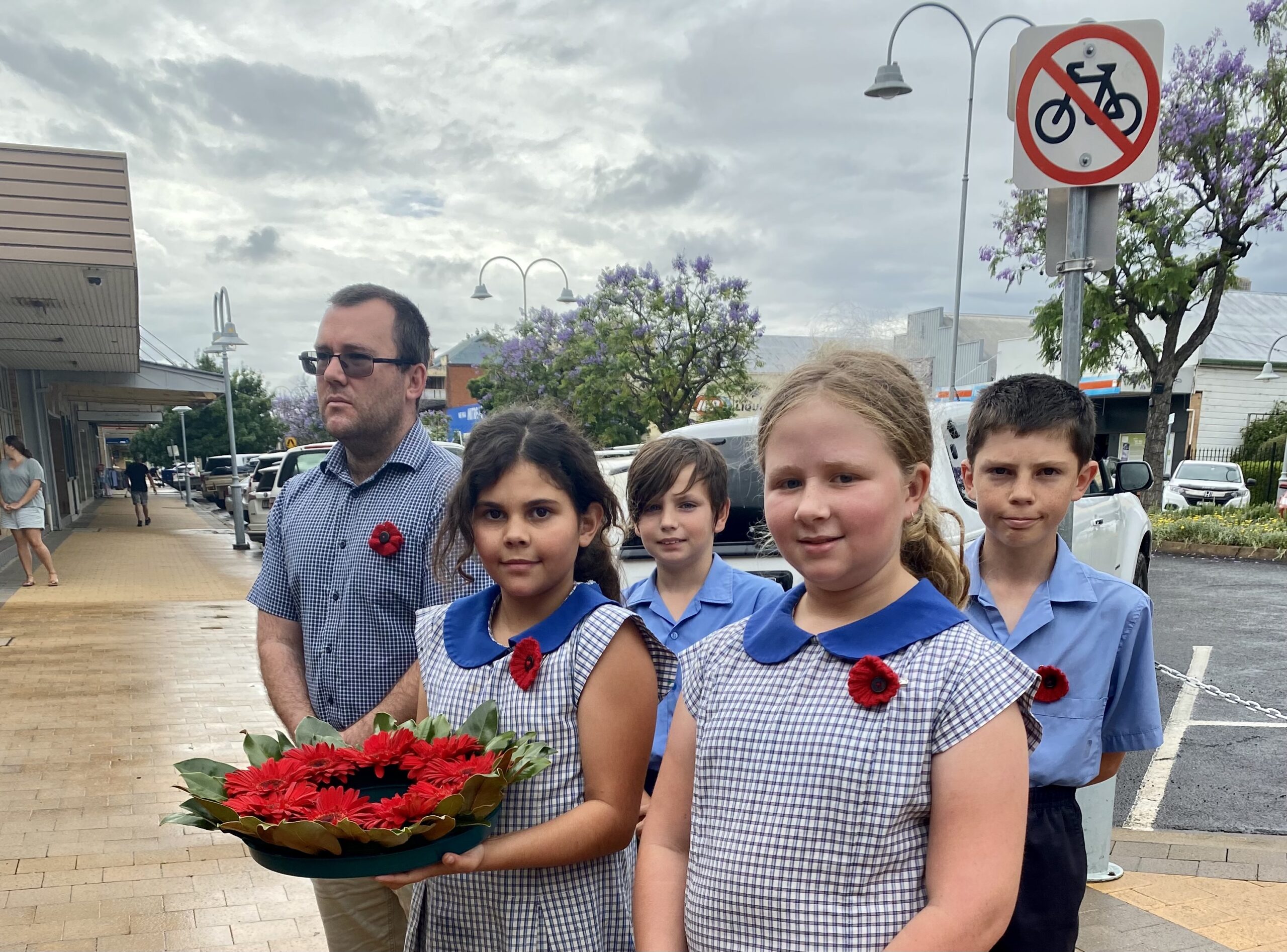Namoi Valley Christian School principal Peter Henderson with students, back, Bailey Mihai and James Smith, front, Vienna Eather and Scarlett Wohling. The students were praised by community members for taking part in the ceremony so respectfully and for considerately laying a wreath at Memory Grove with great care.