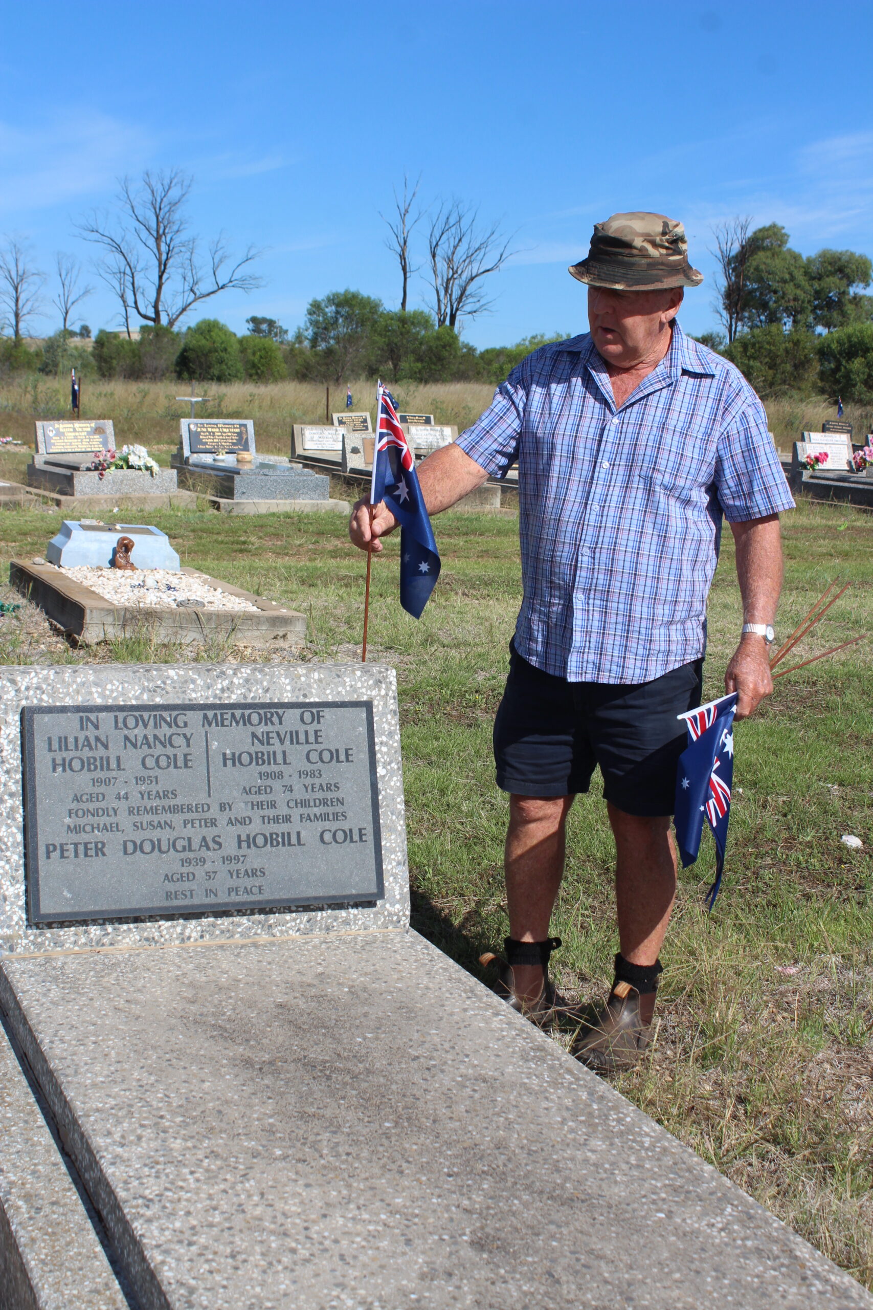 David Grover placing a flag on Neville Cole’s grave.