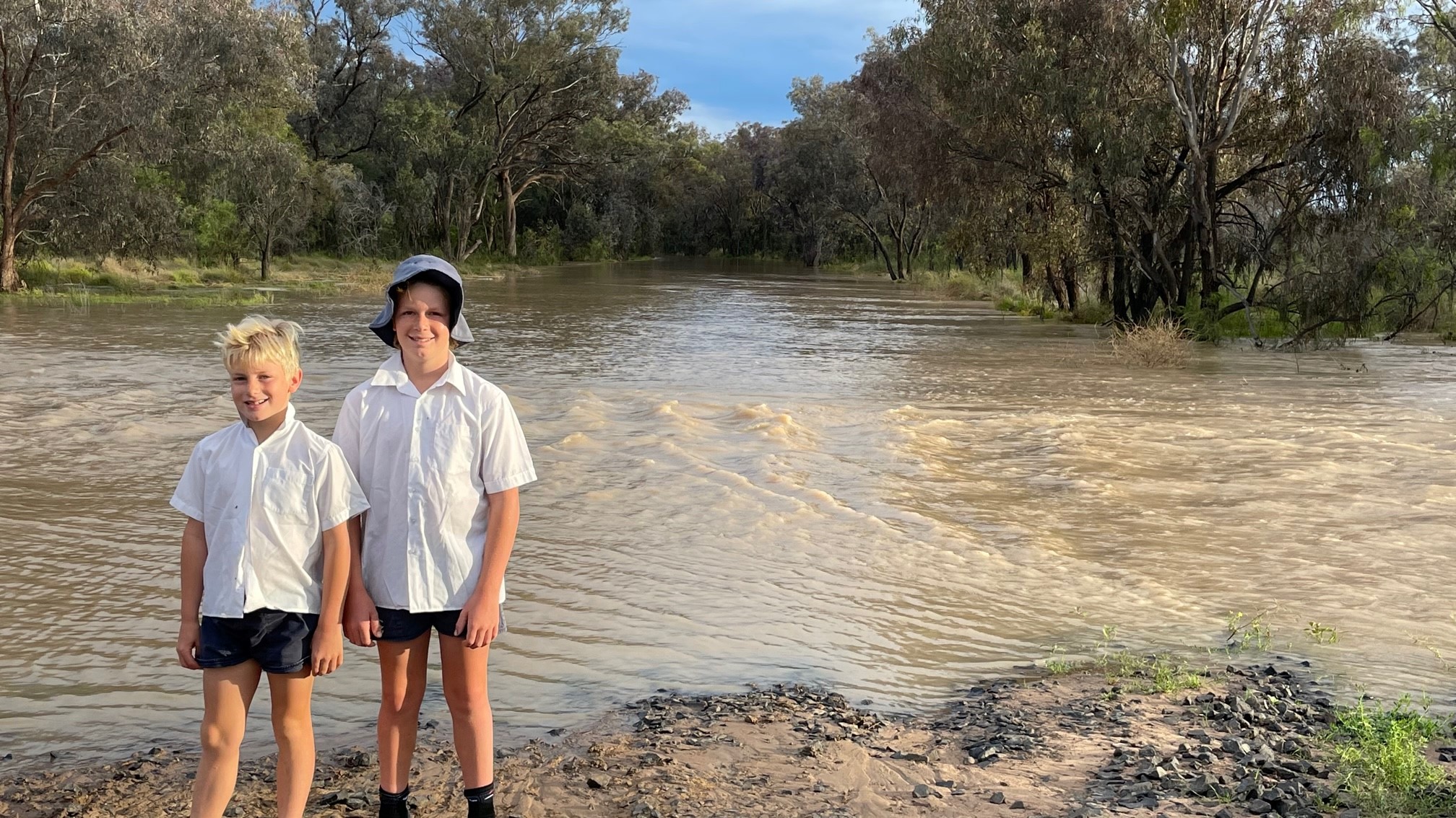 Burren Junction Public School students Jamie and Will Smith at their property’s flooded driveway.