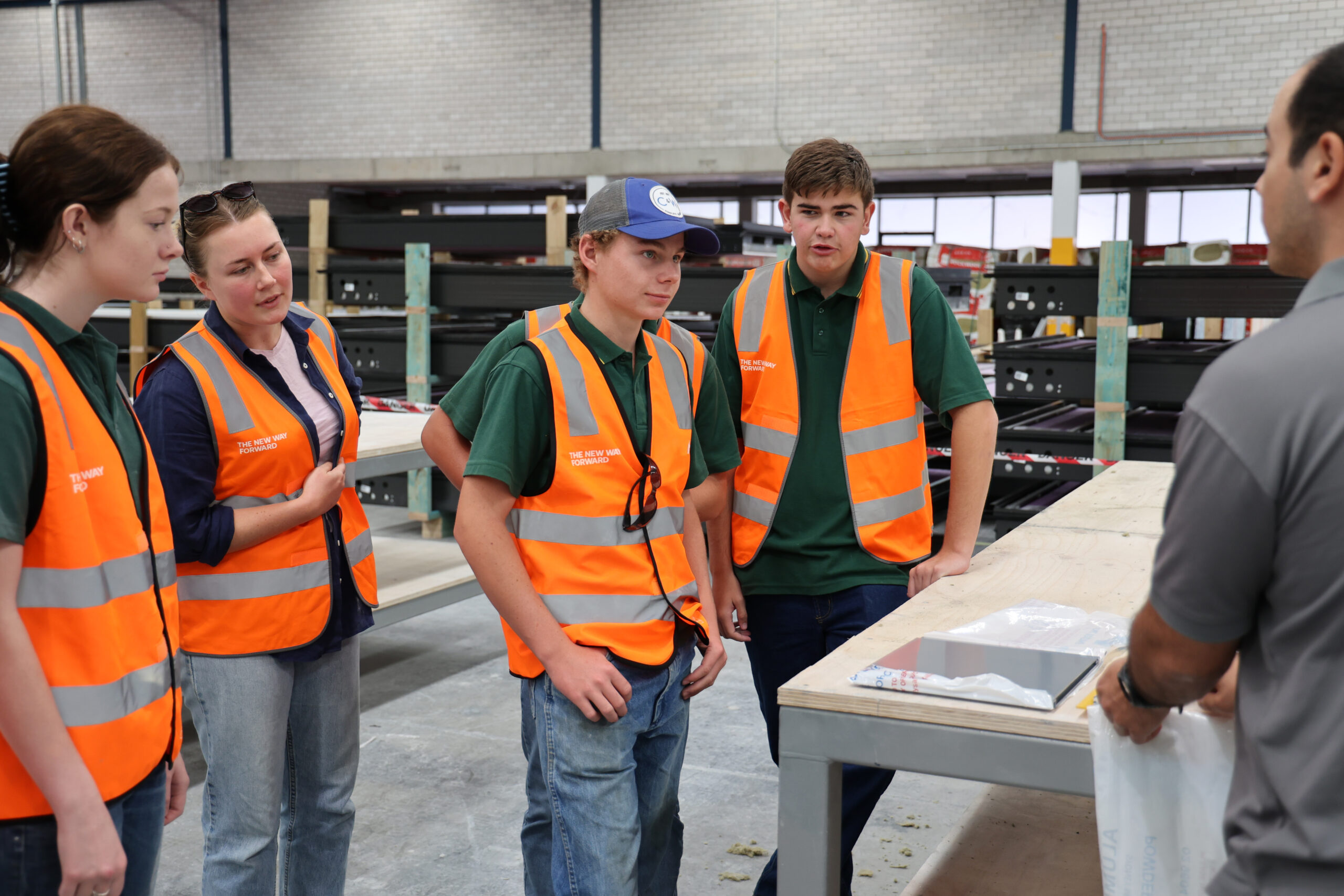 Lindsie Lonnen, teacher Sarah Trevaskis, Jackson Humphries (obscured) Jackson Reynolds, Jye Smith listening to a Built factory staff member discuss how the building components of their new school are being manufactured.
