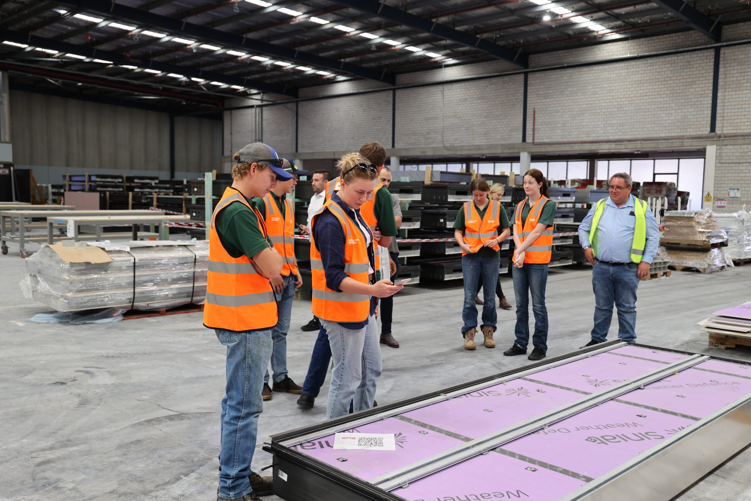 WWHS Student Jackson Reynolds and teacher Sarah Trevasksis examine the panelling. Lavinia Bolton, Lindsie Lonnen and teacher Steve Catt with Built factory staff.