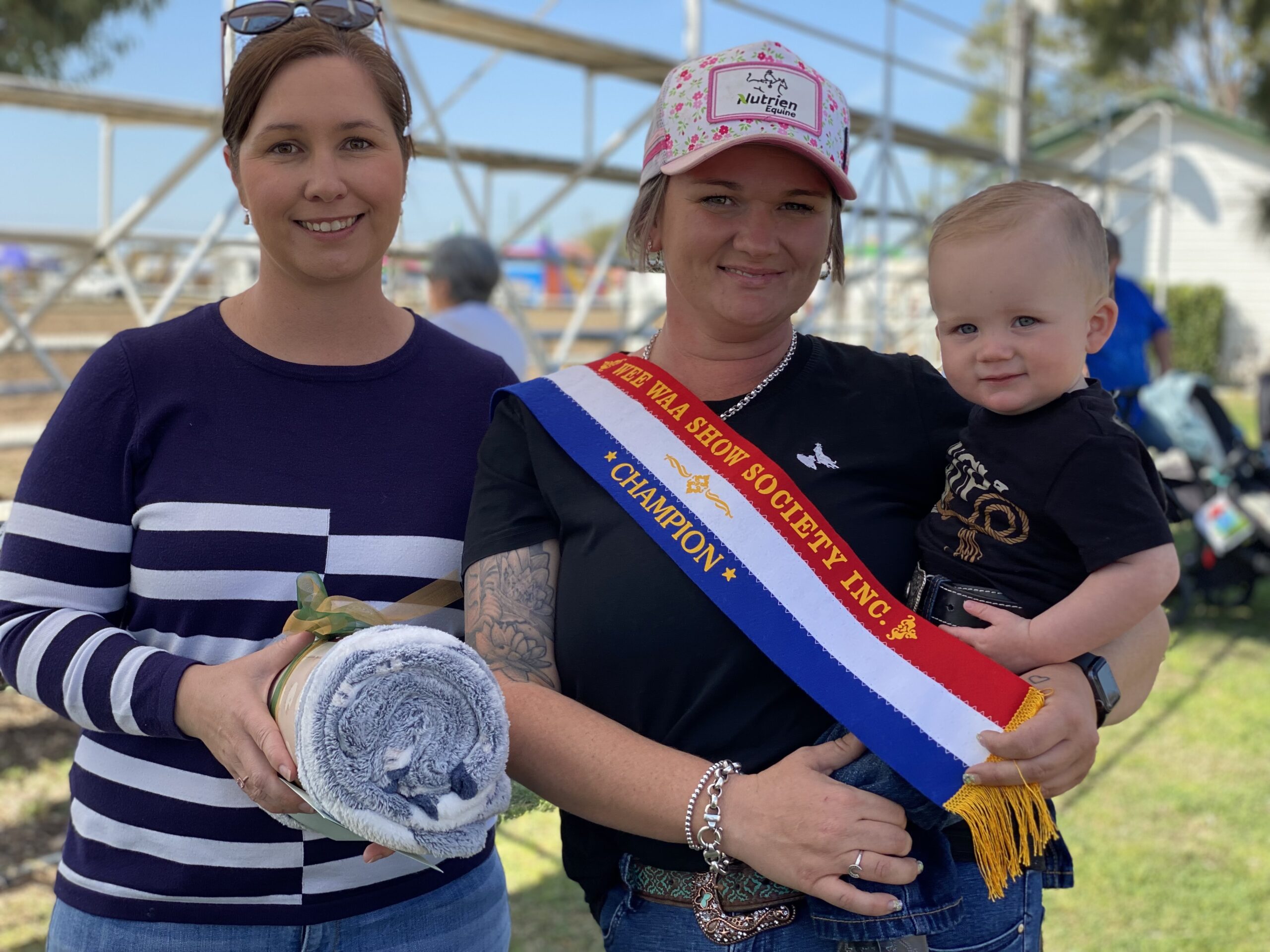Steward Karlee Hatton presenting Lane Booby with the grand championship prize at the baby show on Saturday. Lane is pictured with his mum Ainsley Caulfield.