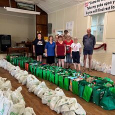 Shared Table overflowing with Christmas hampers and support