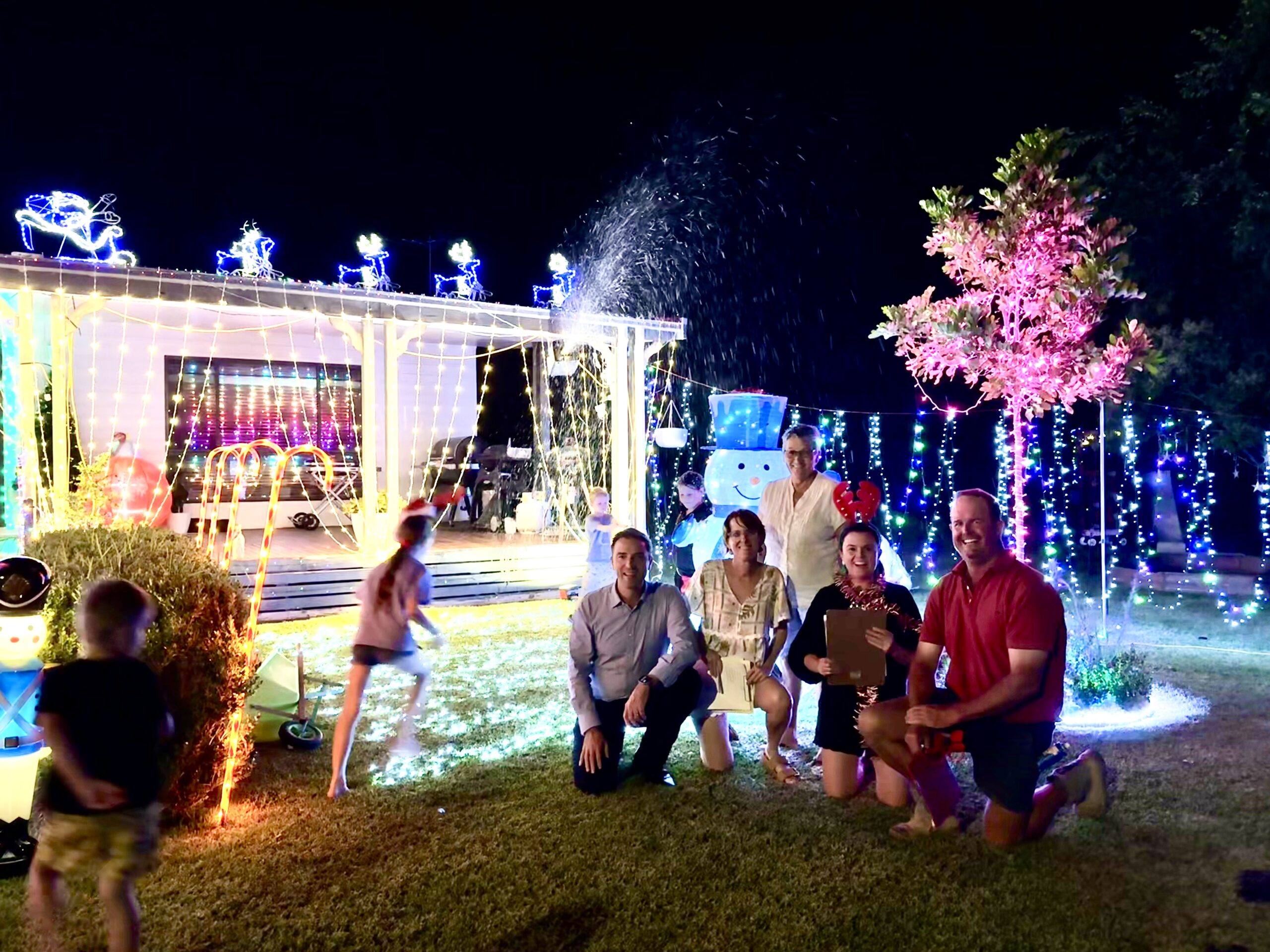 Christmas light comp. organisers Roxanne Whitton and Lisa Pfeffer with judges - NSC mayor Darrell Tiemens, Ali Smith and Angus Moore at the Head family’s snow machine on Kilkenny Court.